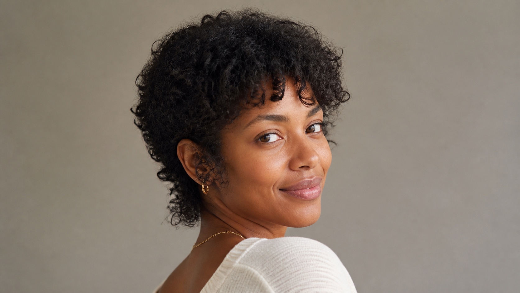 Curly bixie cut with layered crown, soft fringe, and textured nape